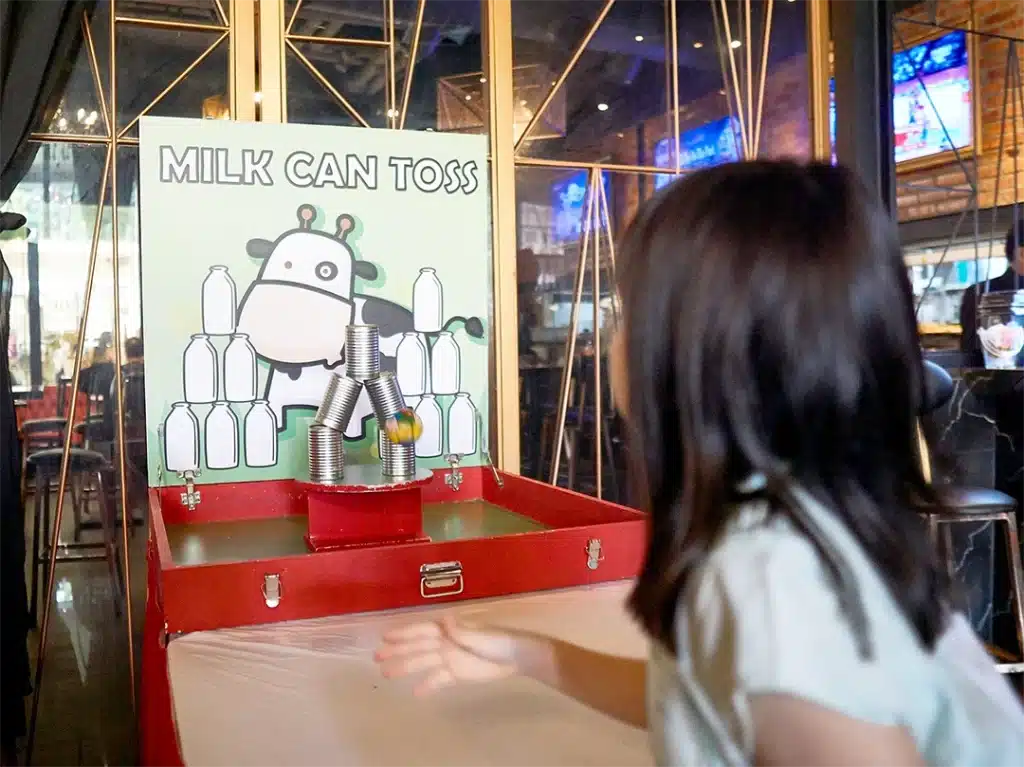 Game booth rental Milk can toss in singapore by Partyfans.